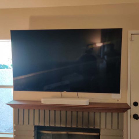 TV on wall over fireplace